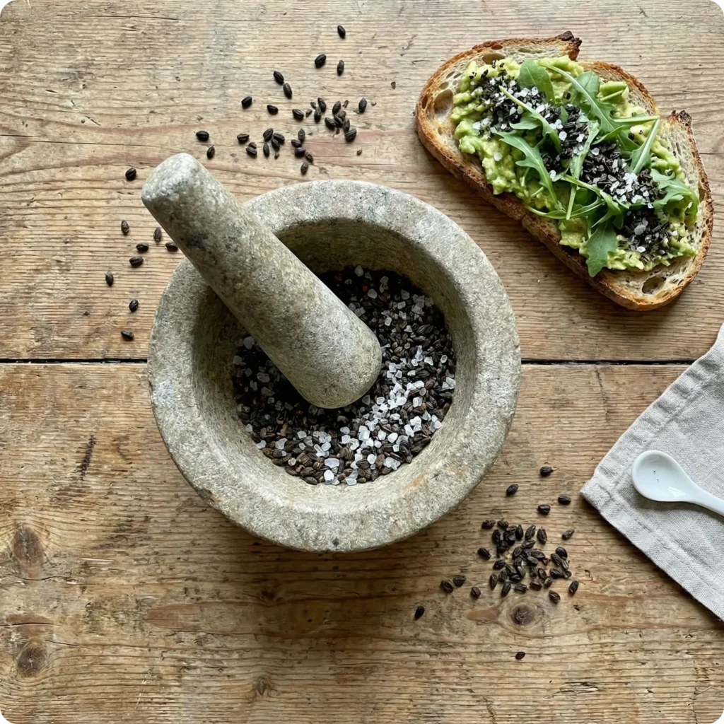 Mortier en pierre contenant un mélange de sel marin et de graines d'ortie pour assaisonner les plats.