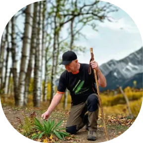 José, fondateur et animateur du blog ''laplumverte'' en train de cueillir du plantain lancéolé lors d'une randonnée.